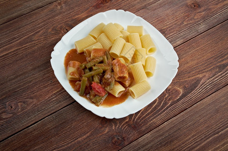 红色的意大利食品面加青豆和番茄酱煮熟的餐厅图片
