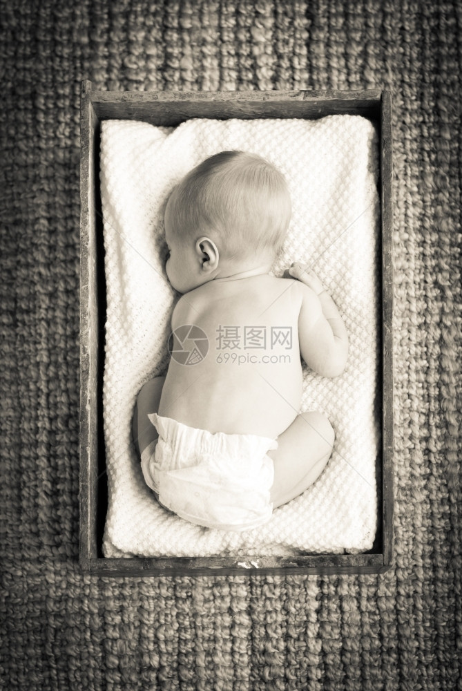 孩子新生婴儿睡在用白布装有的旧木箱内睡眠图片