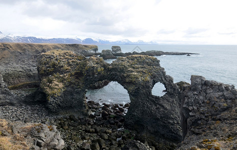 海洋形成冰岛农村崎岖的海岸上拱石岩图片