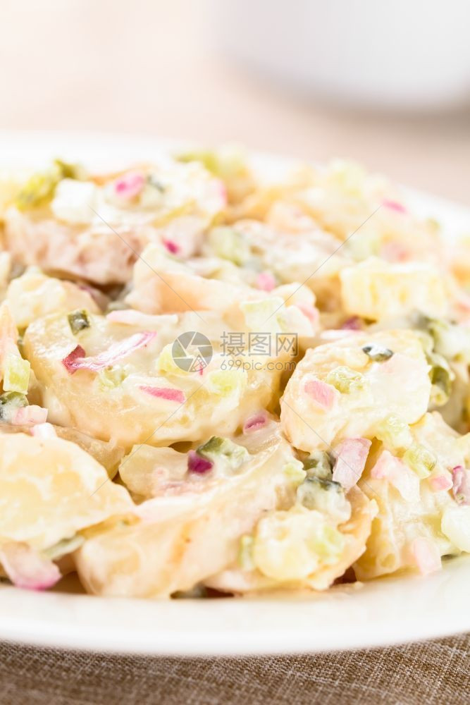 新鲜的食物切片以红洋葱泡菜蛋黄酱和芥子制成的新鲜自土豆沙拉用于板上选择焦点在图像中聚焦新鲜土豆沙拉图片