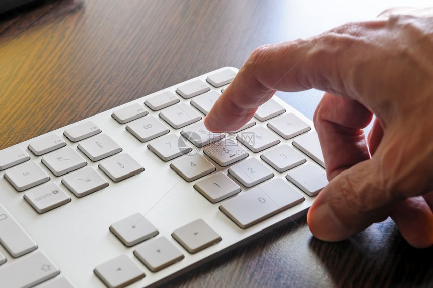 一个老人在用电脑的数字键盘58皮卡桌面外围设备图片