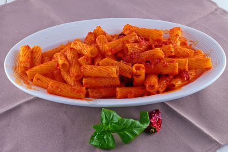 意大利语盘子上满是托尔蒂格利奥尼配有酱汁胡椒和辣食物白色的图片
