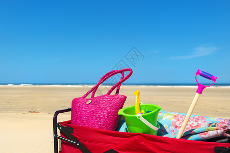 轮子车皮海滩上带度假行李的手提车包图片