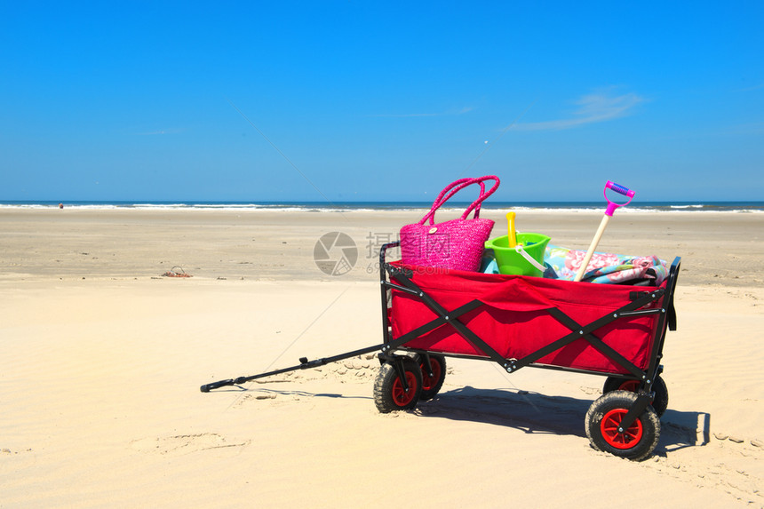 海滩上带度假行李的手提车冲浪家庭大图片