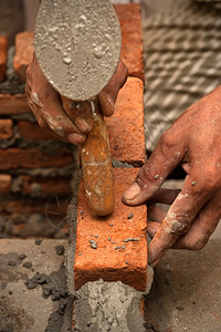 建设者灌浆用水泥铺砖墙的工人具体图片