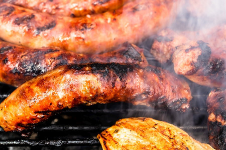 木炭熏制关于烤肉烧和食物概念的自制鸡肉猪牛排和香肠的细节抽烟图片