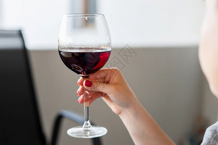 女紧贴着红酒杯子手握着在阳台上白天喝酒的无名主教女子庆典饮料图片