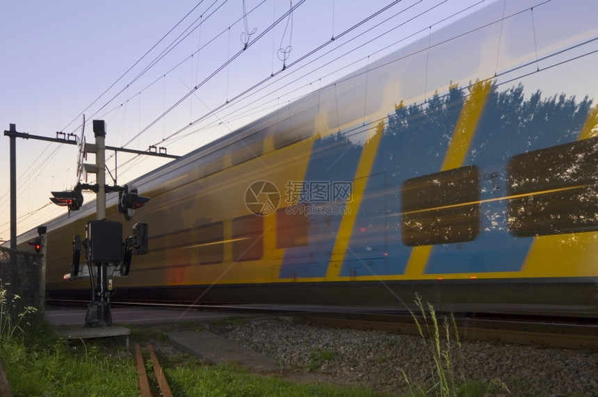 一种栅栏日落时全速乘火车通过绿色图片