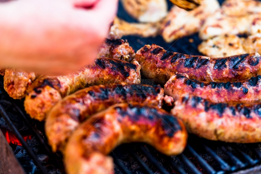 厨师腊肠木炭在花园烧烤肉上香肠和猪排图片