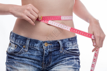 白色的腰部妇女用测量胶带检查胃部度苗条的图片