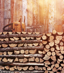 贮存用堆积的木柴肥和老旧链锯挡风化的木墙燃料自然图片