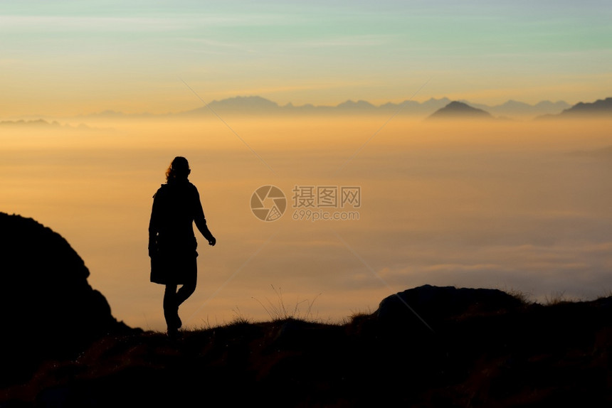 女士健康运动的日落时山中上一个徒步者的休眠山谷里满是雾海图片