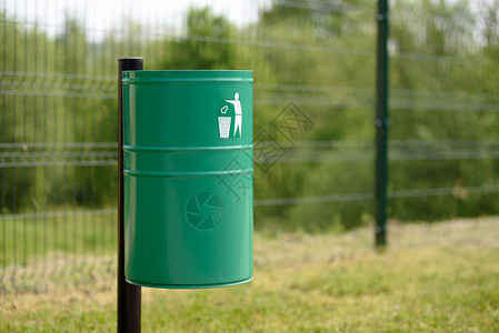 环境污染回收公园或共事业大楼外面的绿色金属垃圾桶在公用建筑图片