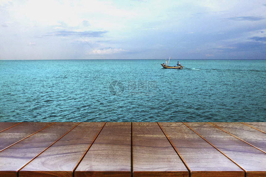 海岸线桌子自然空木制间平台和海上及天空背景的船用于产品显示蒙戴布置的木板表格图片
