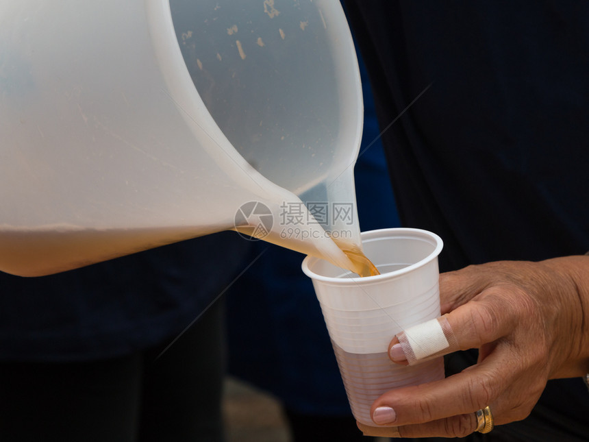 投手湿的在塑料玻璃杯中泡柠檬冰茶点图片