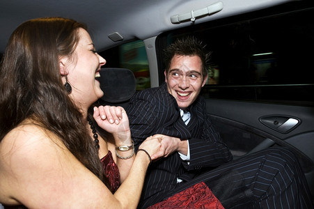 一对情侣在晚上外出后在租车的座玩得开心运动戏弄微笑图片