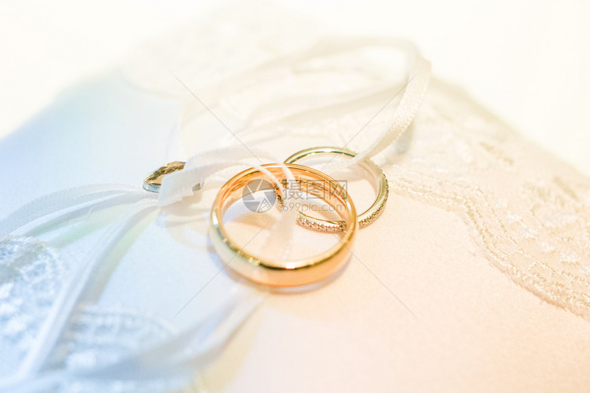 说谎白色枕头上的两个金婚戒特写白色枕头上的两个结婚戒指特写珠宝象征图片