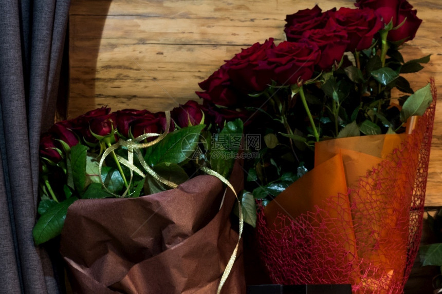 浪漫新鲜的窗帘附近木墙背景上新鲜玫瑰布束靠近图片