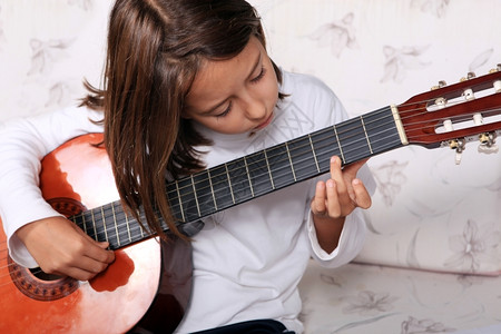 年轻的女孩弹古典吉他可爱的女图片