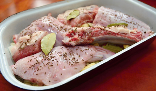 烤锅中未熟的兔子肉和猪片块烘烤准备香芹籽图片