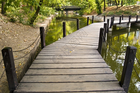 这座桥横跨城市公园的小溪流假期湖平静的图片