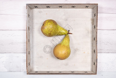 农业收成木制的两个会议梨放在旧木地板上的托盘中两个会议梨放在旧木地板上的托盘中背景图片