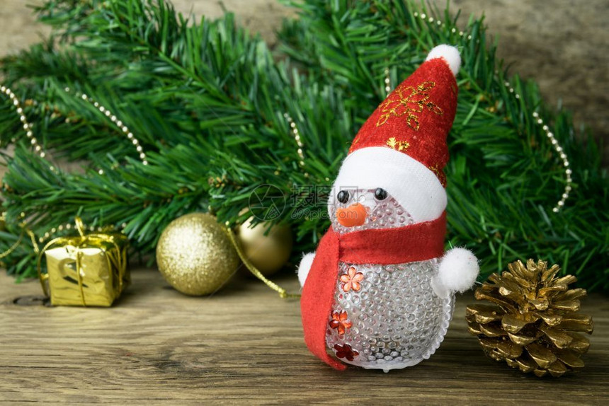 圣诞雪人玩具和旧木本底的圣诞装饰松树木头数字图片