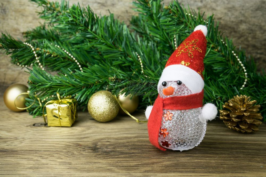 金子圣诞节雪人玩具和旧木本底的圣诞装饰盒子图片