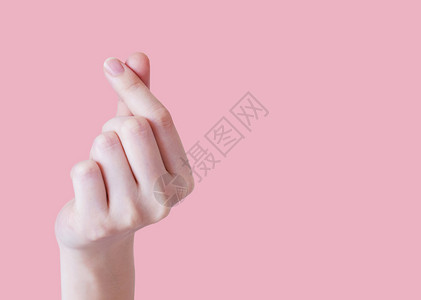 海报韩国指甲爱的概念年轻女手在粉红背景和复制空间上做小心脏图片