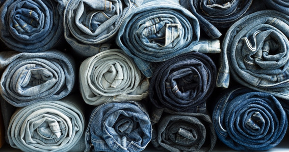 堆叠的蓝色牛仔裤卷现代的子棉布图片