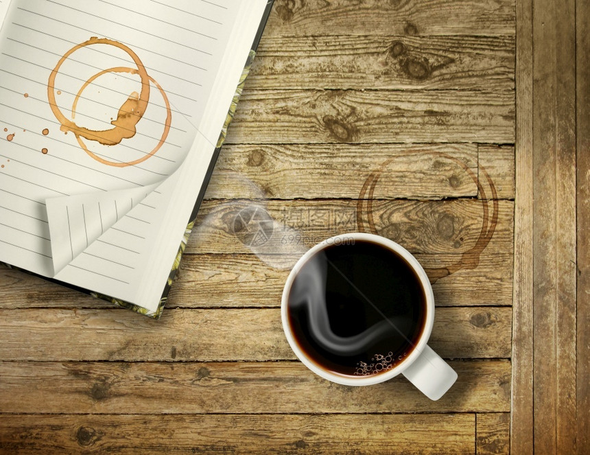 记事本一大杯热黑咖啡在粗木制桌布上带有斑环的彩色戒指药片黑的图片
