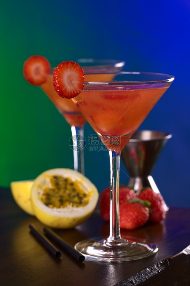 秘鲁鸡尾酒叫做Pisquina由辣椒激情果子和红莓汁新鲜草糖和冰选择焦点关注玻璃前边缘和圆草莓片的前面注百香果酒精图片