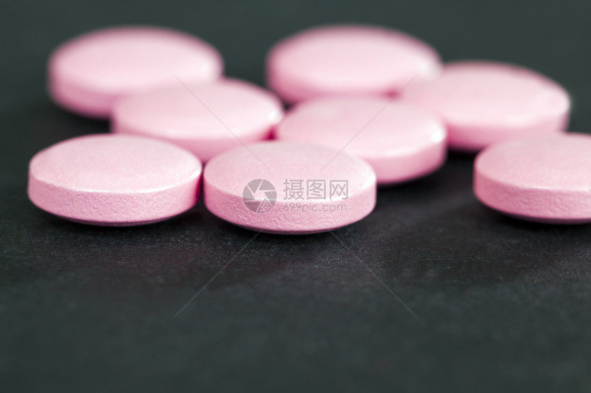 粉红药片躺在一张黑纸背景上检查用于治疗病症的药剂黑粉色品花园的关心图片