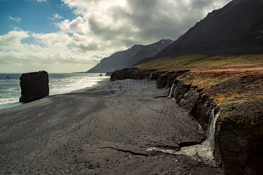冰岛黑海滩上的小瀑布图片