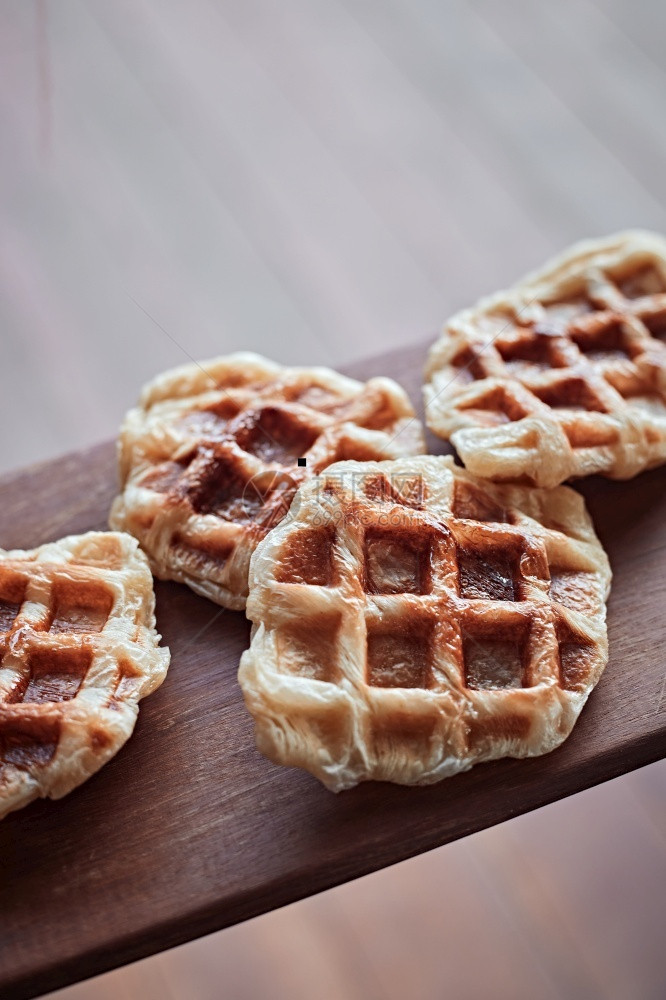 手工制作的CroissantWaffleCroffle在木本背景上自制木头棕色的图片