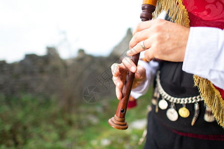 苏格兰风笛管道带有传统服装的风笛播放器细节苏格兰高地背景