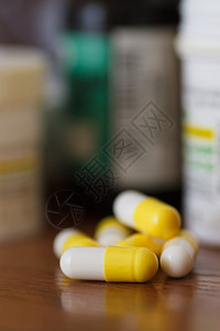 床头抗生素黄白胶囊床边桌子上有药品贴缝合的结片白色图片