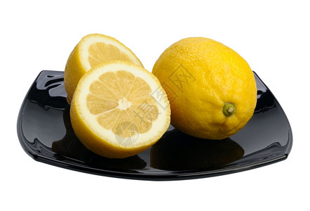 健康圆圈黑色盘子上两个柠檬隔离滴图片