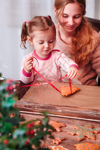 假期桌子女孩们用丝带烤着圣诞姜饼干烘烤的图片