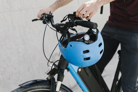合身紧的骑自行车人把头盔插冰手电池城市图片