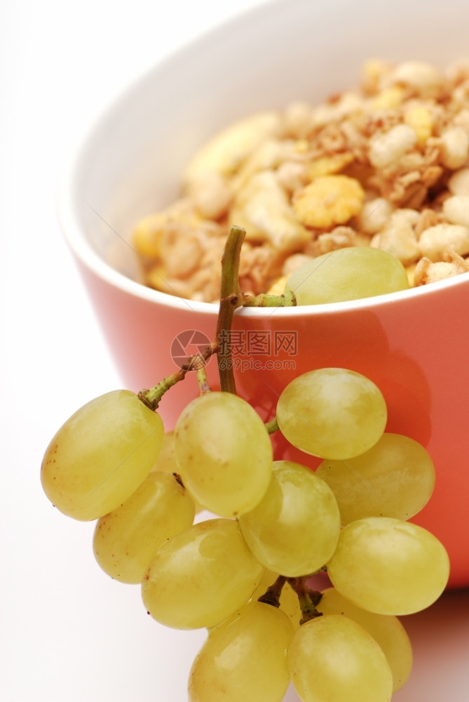 素食主义者健康的早餐一堆葡萄在碗穆斯利白人背景有选择焦点垂直作物一种纤维图片