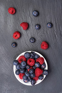 有机的散布在黑背景图视上的新鲜草莓和浆果美味的山图片