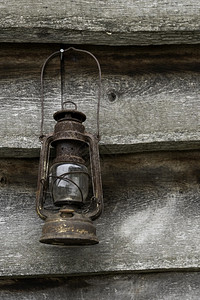 陈年古董绞刑木板墙上的老旧生锈花园灯笼图片