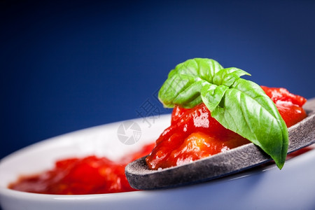 蓝色背景的新鲜意大利番茄酱有叶味道汤比萨图片