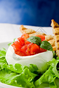 意大利语乳制品用西红柿和烤肉塞满水牛马zzarella蓝底生菜切片图片