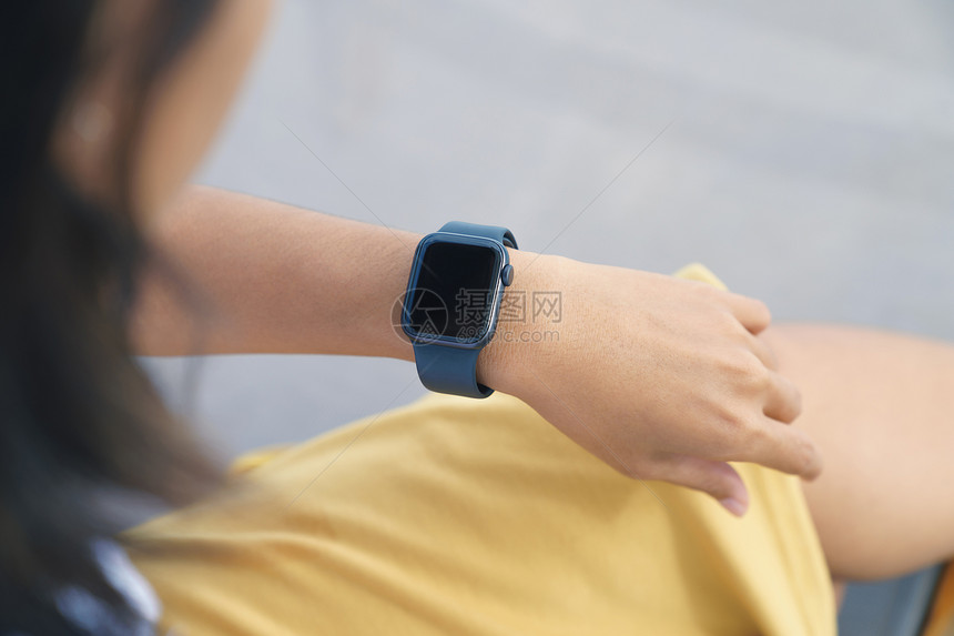 屏幕现代的触碰一个女人在看着她的聪明手表图片