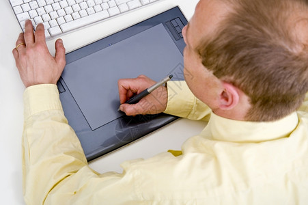 笔记本电脑监视器高级设计师在一张图形平板上工作手放在键盘的控制上药片图片