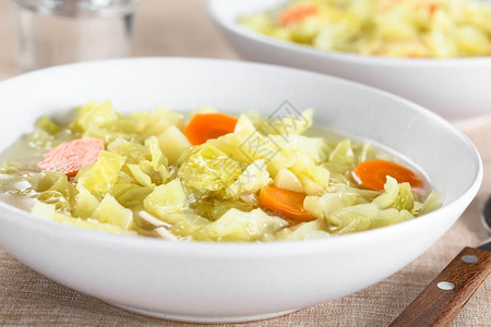 新鲜自制素食卷心菜汤配有胡萝卜和土豆用于碗中选择焦点聚于影像中间的新鲜VeganCABBAGSOUP素食主义者炖自然背景