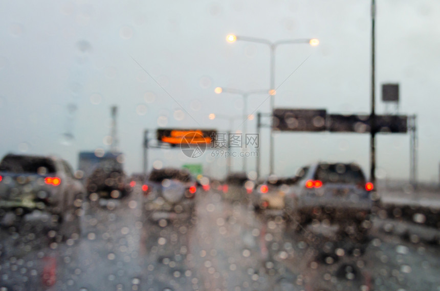 驾驶降低镇路上的一辆模糊车被拖着雨滴挡在路边图片