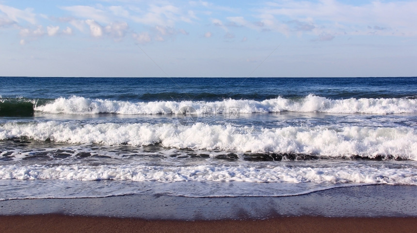 海浪冲洗黑滩的沙地平线海岸户外图片